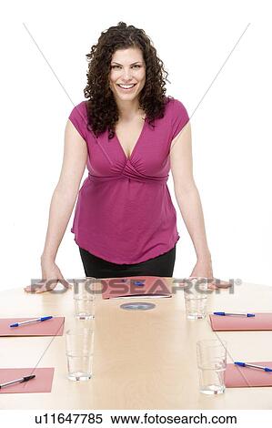 Businesswoman standing in boardroom smiling View Large Photo Image Stock Photography - Businesswoman standing in boardroom smiling. Fotosearch