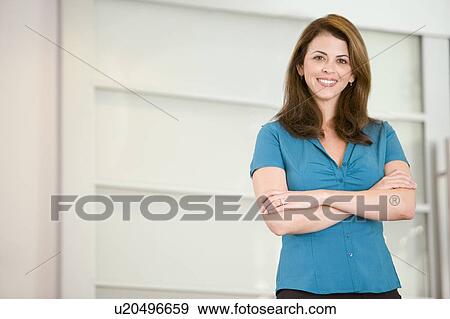 Businesswoman standing indoors smiling View Large Photo Image Stock Photo - Businesswoman standing indoors smiling. Fotosearch