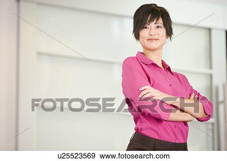 Stock Photo - Businesswoman standing indoors smiling. Fotosearch