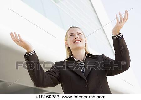 Businesswoman standing outdoors by building with hands out smiling View Large Photo Image Stock Image - Businesswoman standing outdoors by building with hands out smiling. Fotosearch