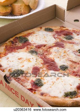 Stock Photograph - Cheese, Tomato And Pesto Pizza In A Take Away Box With Garlic Bread. Fotosearch