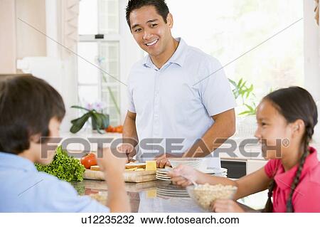 Children Having Breakfast While Dad Prepares Food View Large Photo Image Stock Image - Children Having Breakfast While Dad Prepares Food. Fotosearch