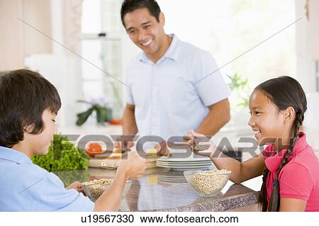Children Having Breakfast While Dad Prepares Food View Large Photo Image Stock Image - Children Having Breakfast While Dad Prepares Food. Fotosearch
