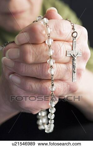Stock Photo - Close-Up Of Elderly Person Holding Rosary Beads. Fotosearch