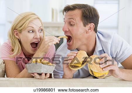 Stock Image - Couple Enjoying Burgers Together. Fotosearch