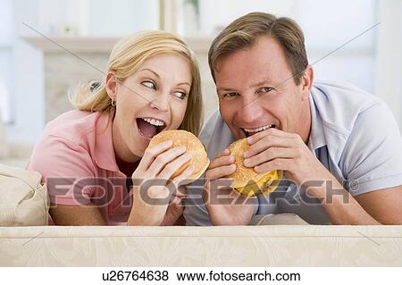 Couple Enjoying Burgers Together View Large Photo Image Stock Photo - Couple Enjoying Burgers Together. Fotosearch