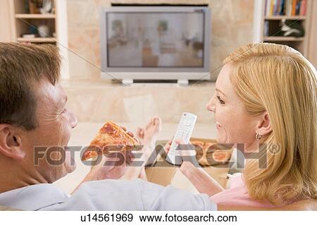 Couple Enjoying Pizza In Front Of TV View Large Photo Image Stock Photo - Couple Enjoying Pizza In Front Of TV. Fotosearch