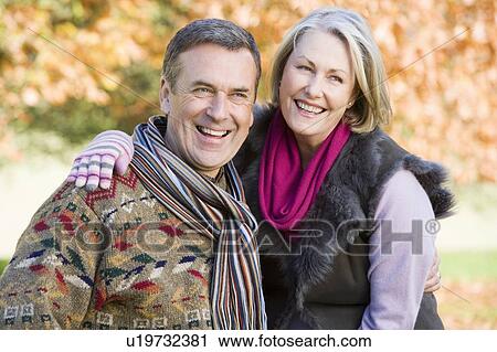 Couple outdoors embracing and smiling (selective focus) View Large Photo Image Stock Image - Couple outdoors embracing and smiling (selective focus). Fotosearch