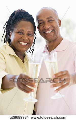 Couple toasting champagne and smiling View Large Photo Image Picture - Couple toasting champagne and smiling. Fotosearch