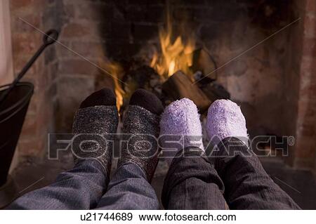 Couple's feet warming at a fireplace View Large Photo Image Stock Photo - Couple's feet warming at a fireplace. Fotosearch