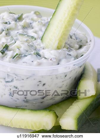 Stock Photo - Cucumber Dipped In Tzatziki. Fotosearch