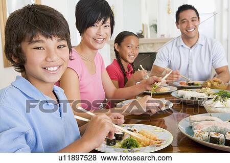 Stock Photo - Family Eating A meal, mealtime Together . Fotosearch
