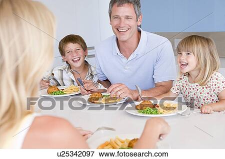 Stock Photo - Family Eating A meal, mealtime Together . Fotosearch