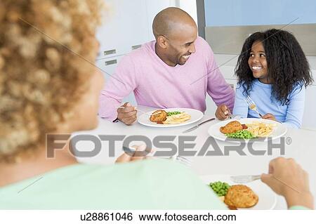 Family Eating A meal, mealtime Together View Large Photo Image Stock Photograph - Family Eating A meal, mealtime Together . Fotosearch