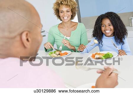 Stock Photograph - Family Eating A meal, mealtime Together . Fotosearch