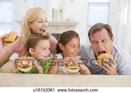 Stock Image - Family Eating Cheeseburgers Together. Fotosearch