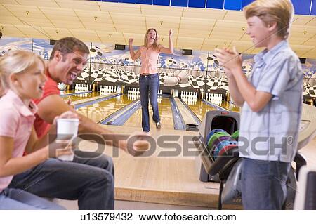 Family in bowling alley cheering and smiling View Large Photo Image Stock Image - Family in bowling alley cheering and smiling. Fotosearch
