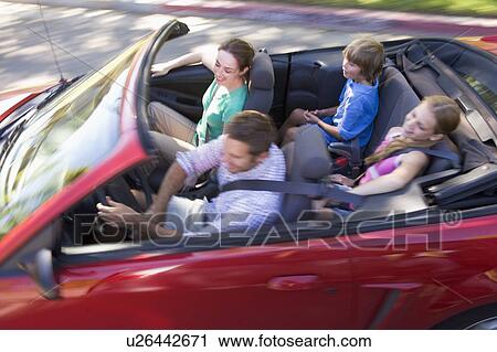 Stock Image - Family in convertible car smiling. Fotosearch