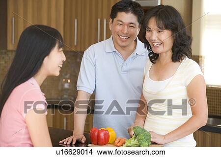 Picture - Family Laughing While Preparing meal, mealtime. Fotosearch
