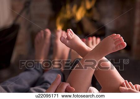 Family of feet warming at a fireplace View Large Photo Image Stock Image - Family of feet warming at a fireplace. Fotosearch