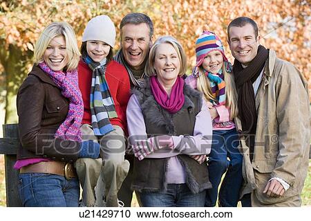 Stock Image - Family outdoors at park smiling (selective focus). Fotosearch