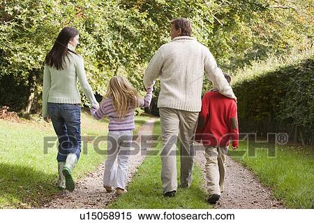 Stock Photography - Family outdoors walking on path holding hands (selective focus). Fotosearch