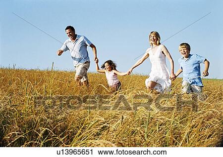 Family running outdoors holding hands smiling View Large Photo Image Stock Image - Family running outdoors holding hands smiling. Fotosearch