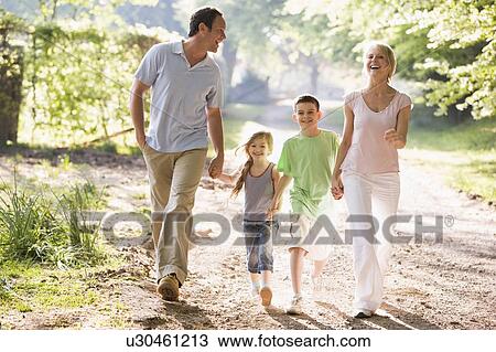 Family running outdoors holding hands and smiling View Large Photo Image Stock Image - Family running outdoors holding hands and smiling. Fotosearch