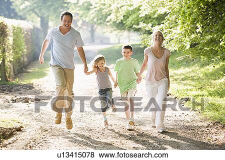 Stock Photo - Family running outdoors holding hands and smiling. Fotosearch