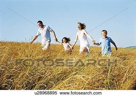 Family running outdoors holding hands smiling View Large Photo Image Stock Photography - Family running outdoors holding hands smiling. Fotosearch