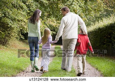 Family walking on path outdoors smiling (selective focus) View Large Photo Image Stock Photo - Family walking on path outdoors smiling (selective focus). Fotosearch