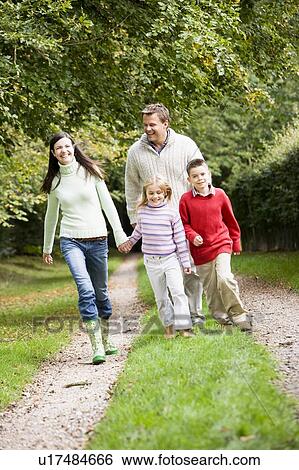 Family walking on path outdoors smiling (selective focus) View Large Photo Image Stock Photograph - Family walking on path outdoors smiling (selective focus). Fotosearch