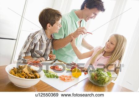 Father And Children Prepare A meal, mealtime Together View Large Photo Image Stock Photo - Father And Children Prepare A meal, mealtime Together . Fotosearch