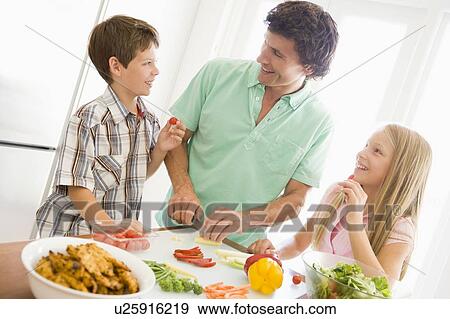 Stock Photo - Father And Children Prepare A meal, mealtime Together . Fotosearch