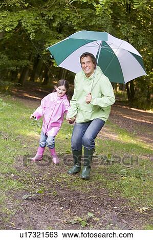 Father and daughter outdoors with umbrella smiling View Large Photo Image Stock Image - Father and daughter outdoors with umbrella smiling. Fotosearch