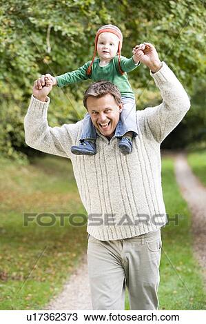 Stock Image - Father giving baby son piggyback. Fotosearch