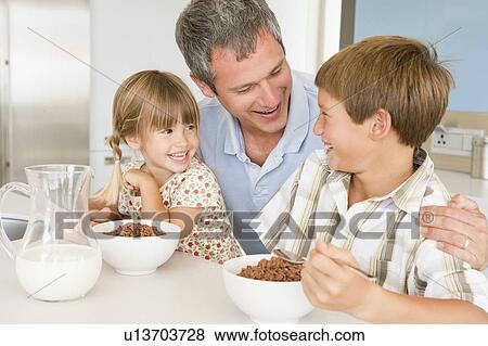 Stock Photo - Father Sitting With Children As They Eat Breakfast . Fotosearch