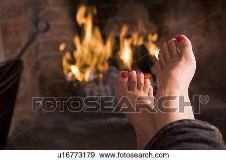 Stock Photo - Feet warming at a fireplace. Fotosearch