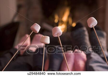 Feet warming at a fireplace with marshmallows on sticks View Large Photo Image Stock Image - Feet warming at a fireplace with marshmallows on sticks. Fotosearch