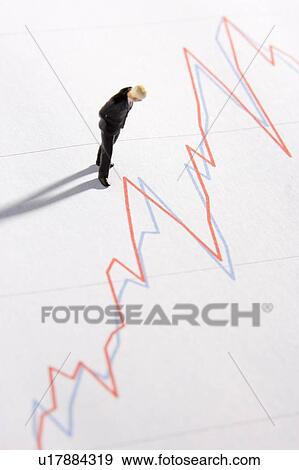 Stock Photo - Figurine Of A Businessman Standing On A Line Graph. Fotosearch