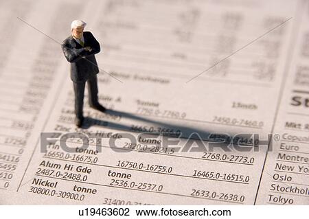 Stock Image - Figurine Of A Businessman With Arms Crossed Standing On A Financial Newspaper. Fotosearch