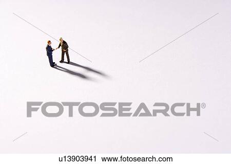 Stock Image - Figurines Of Two Businessmen Shaking Hands. Fotosearch