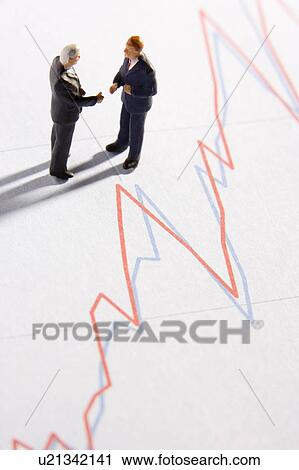 Stock Image - Figurines Of Two Businessmen Shaking Hands On A Line Graph. Fotosearch