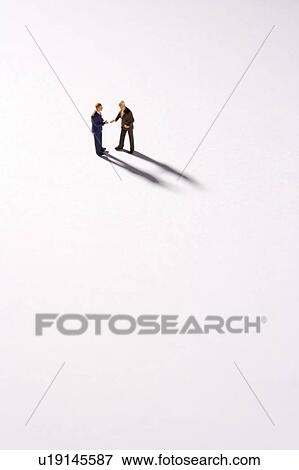 Stock Photo - Figurines Of Two Businessmen Shaking Hands. Fotosearch