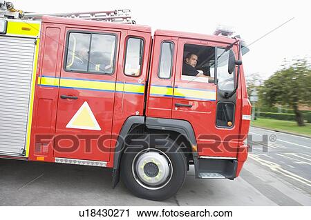 Firefighters driving fire engine out of driveway View Large Photo Image Stock Image - Firefighters driving fire engine out of driveway. Fotosearch