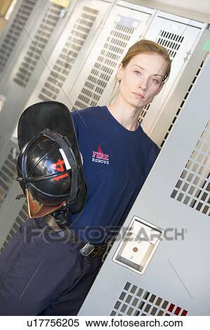 Firewoman getting her helmet out of her locker in fire station locker room (depth of field) View Large Photo Image Stock Photography - Firewoman getting her helmet out of her locker in fire station locker room (depth of field). Fotosearch