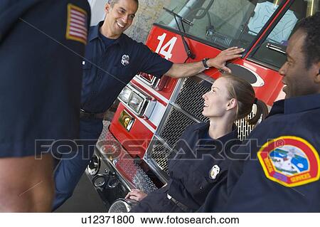Four firefighters talking by fire engine View Large Photo Image Stock Image - Four firefighters talking by fire engine. Fotosearch