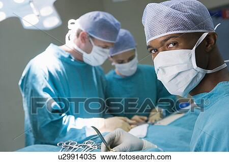 Stock Photography - Four Surgeons Getting Ready To Operating On A Patient. Fotosearch