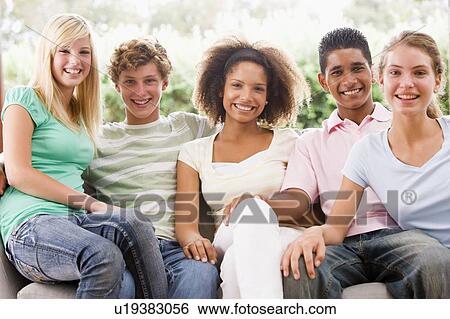 Group Of Teenagers Sitting On A Couch View Large Photo Image Stock Photograph - Group Of Teenagers Sitting On A Couch. Fotosearch