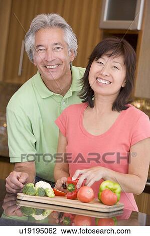 Stock Image - Husband And Wife Preparing meal, mealtime Together. Fotosearch